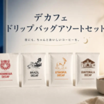 Four decaf coffee packets Indonesia Brazil Ethiopia Guatemala stand on a white surface with a coffee cup and soft evening backdrop