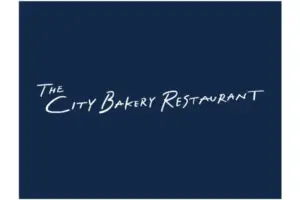 Logo for The City Bakery Restaurant in white script on a dark blue background