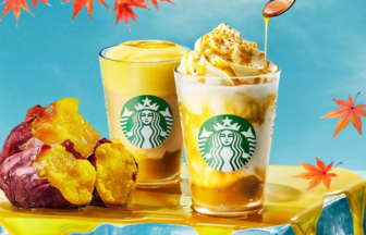 Two Starbucks drinks with whipped cream and caramel drizzle sit on a bright yellow table surrounded by orange autumn leaves and a roasted sweet potato half