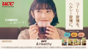 Smiling woman holding a cup of coffee in a UCC ad with branding and a product lineup at the bottom right