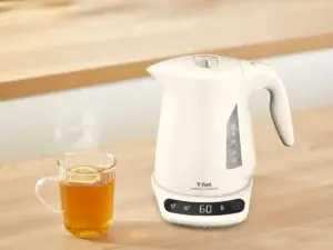 8afcc362b2fb420dba1ce04ca5f7a8e8 | コーヒーステーション White electric kettle with digital control on a base next to a steaming mug of tea on a wooden table