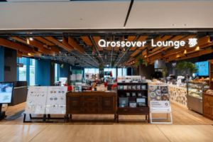Interior of a cafe called Qrossover Lounge featuring wooden ceiling beams a long wooden counter and pastry display cases