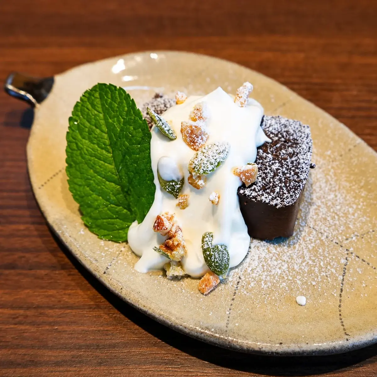 素朴な陶器の皿に盛られたチョコレートケーキとホイップクリーム
