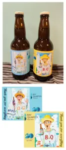 Two dark beer bottles with illustrated labels featuring a man in a yellow hat placed on a striped cloth against a pale wall