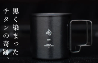Black titanium mug with a geometric logo on the front and vertical Japanese text along the left edge.