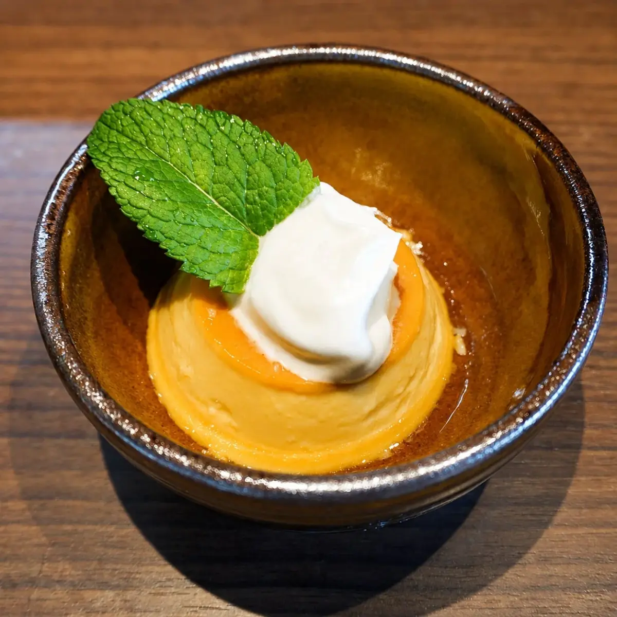 陶器の器に入った、カラメルソースがかかった黄色いプリン