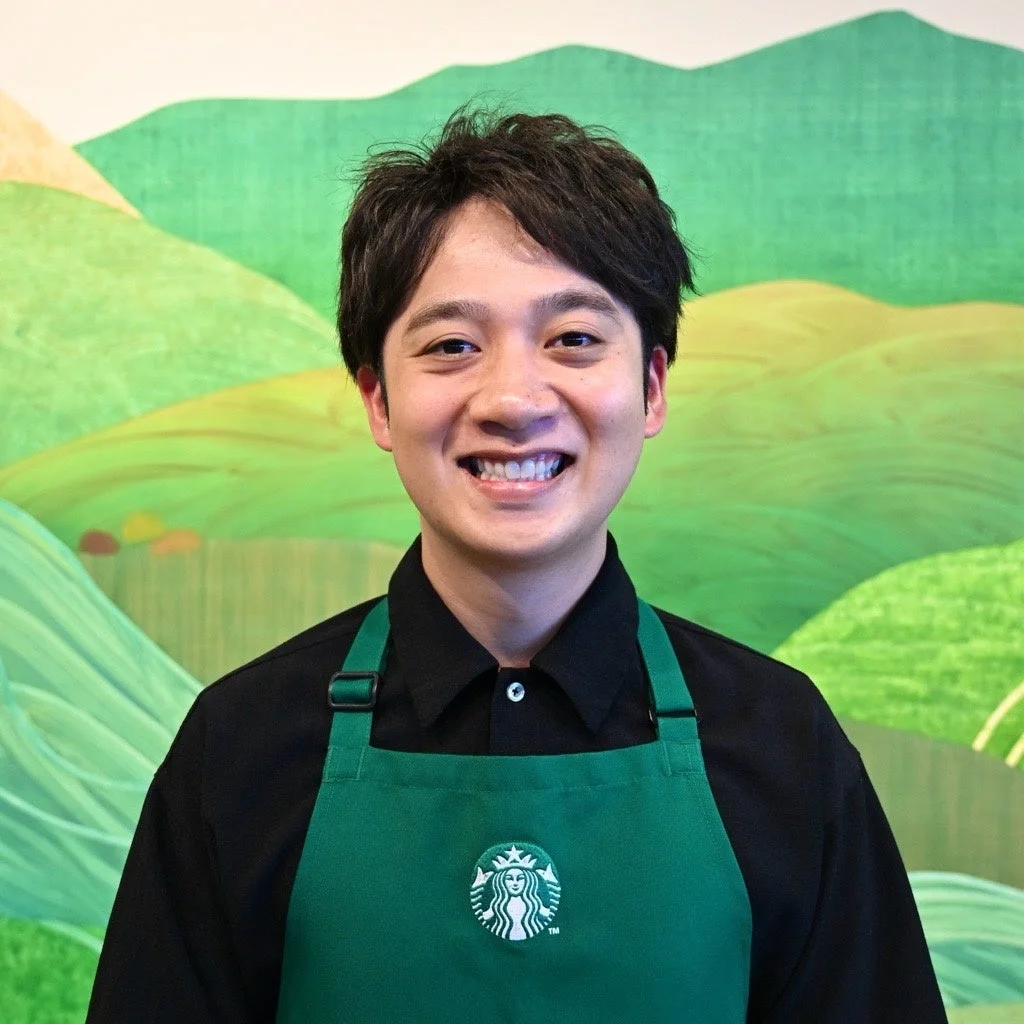 スターバックスのエプロンを着用し笑顔の男性バリスタ