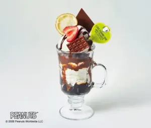 Sundae in a glass mug topped with a lemon slice strawberry chocolate bar cream and a Peanuts tag