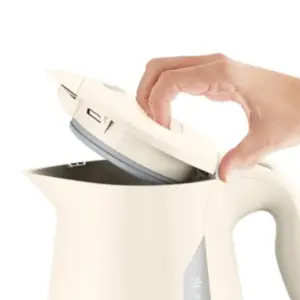 Person opens the lid of a white electric kettle preparing to fill it