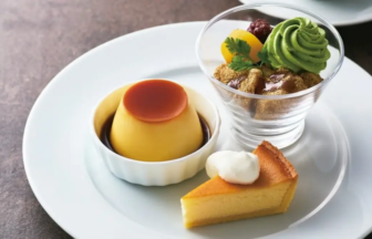 Assorted desserts on a white plate caramel flan in a ramekin green tea parfait with crumbs and a slice of yellow cake with whipped cream