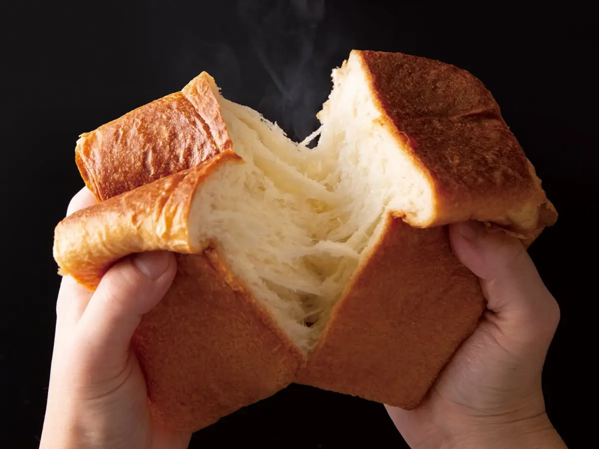 焼きたての食パンを両手でちぎっている様子